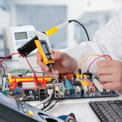 Repairman fixes electronic equipment in service center
