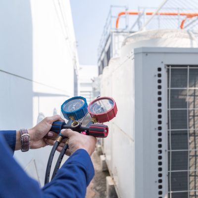 Technician is checking air conditioner ,measuring equipment for filling air conditioners.
